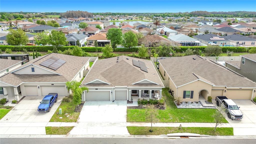 An aerial view shows three suburban houses with driveways and lawns in a residential neighborhood — 4471 HOLSTEIN STREET, ST CLOUD, FL