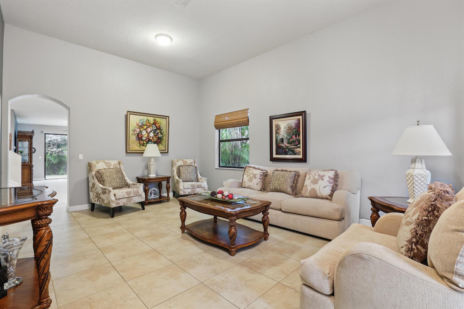 A living room features beige tile flooring, neutral walls, a sofa, and several armchairs — 3801 Aspen Leaf Drive, Boynton Beach FL 33436, BOYNTON BEACH, FL