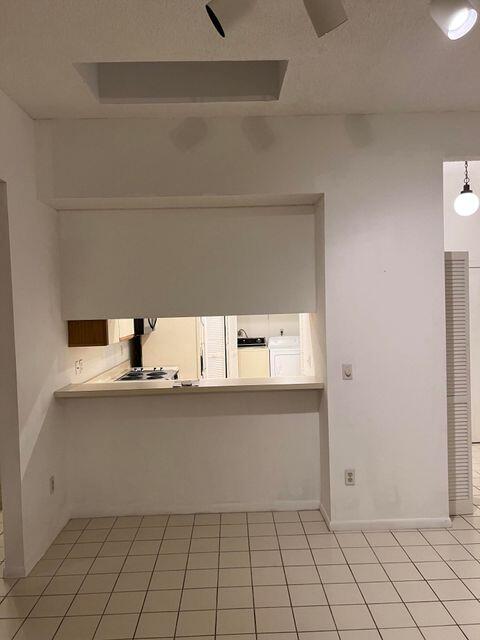 A kitchen pass-through window overlooks a tiled dining area with a recessed ceiling light — 7535 La Paz Boulevard # 307, Boca Raton FL 33433, BOCA RATON, FL