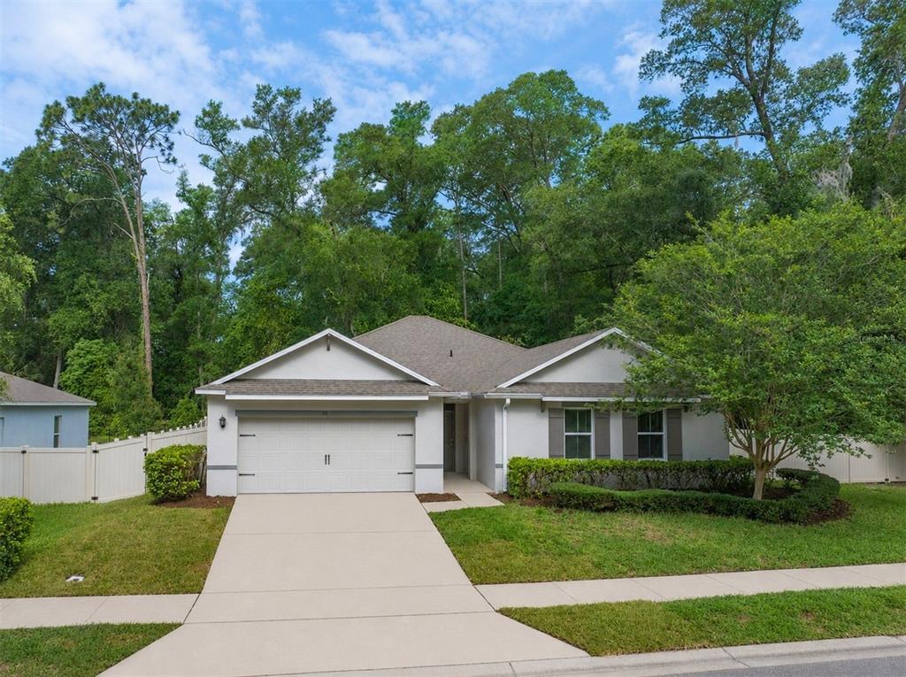 A single-story house with a two-car garage, light-colored siding, and a landscaped front yard — 111 POINT PLEASANT ROAD, DELAND, FL