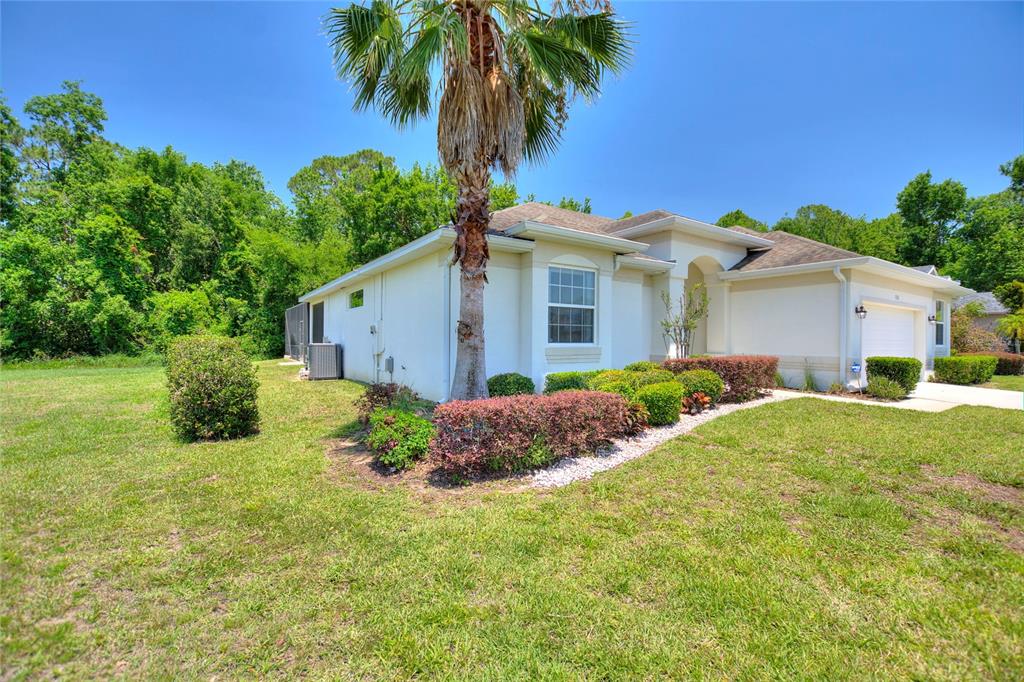 A single-story house with a palm tree, manicured shrubs, and a lawn under a blue sky — 1316 GOLF COURSE PARKWAY, DAVENPORT, FL