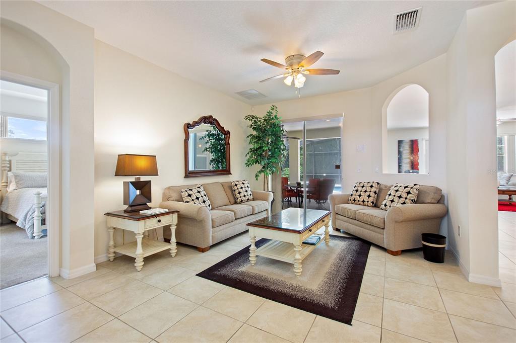 A living room features two beige sofas, a coffee table, and tile flooring — 1316 GOLF COURSE PARKWAY, DAVENPORT, FL