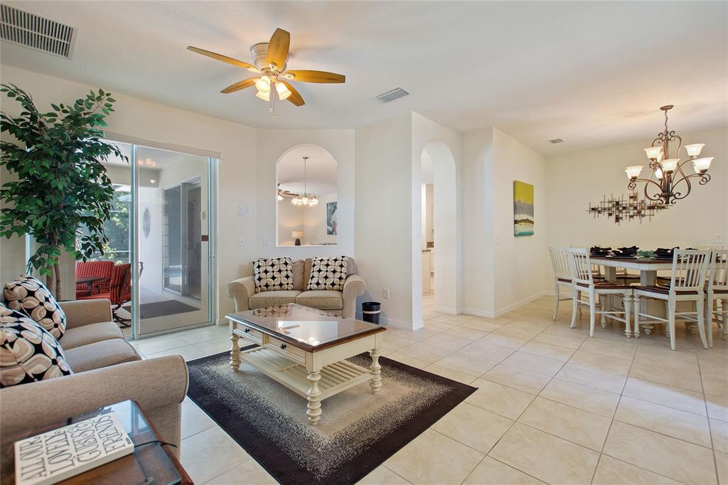 A living room and dining area feature tile floors, a ceiling fan, and arched openings — 1316 GOLF COURSE PARKWAY, DAVENPORT, FL