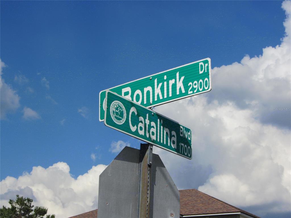 A street sign displays the names Ronkirk Dr and Catalina Blvd against a blue sky — 1688 CATALINA BLVD, DELTONA, FL