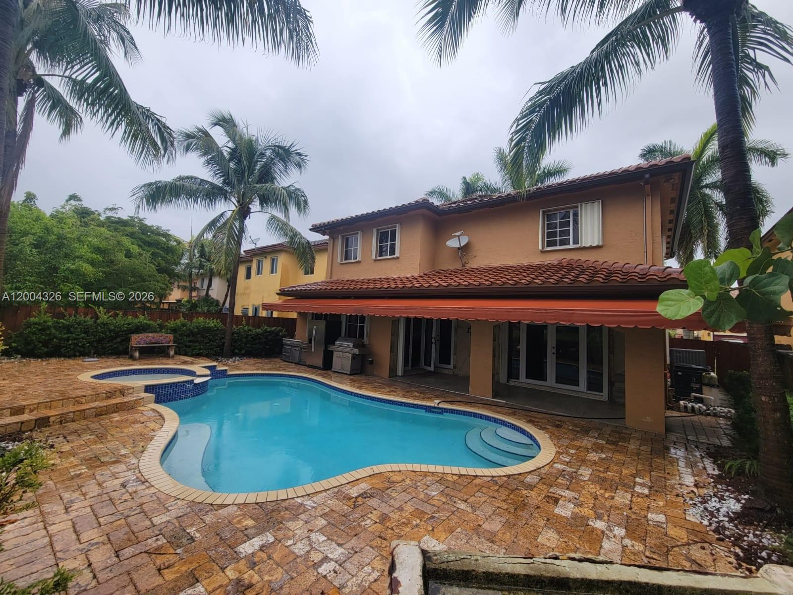 A two-story house with a pool, patio, and retractable awning in the backyard — 2614 NE 41st Rd, Homestead FL 33033, HOMESTEAD, FL