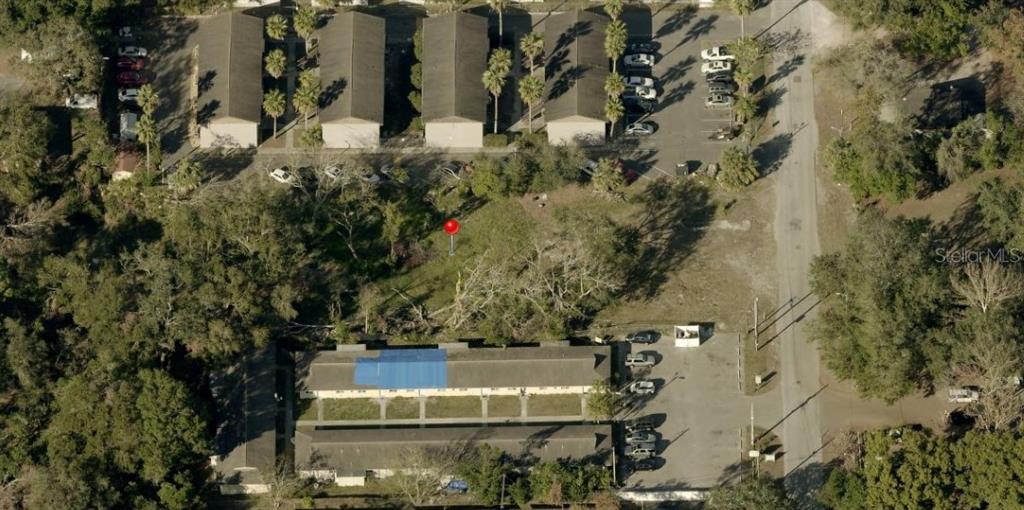 An aerial view shows apartment buildings, parking lots, and a vacant lot with a red marker — 11724 N 14TH STREET, TAMPA, FL