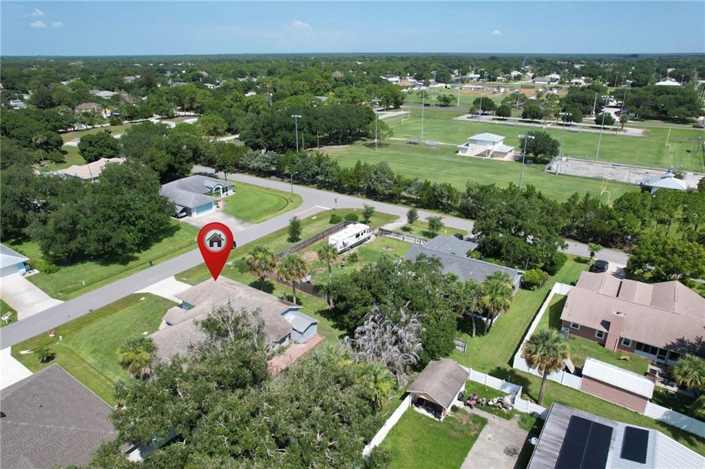 An aerial view shows a residential house with a red location pin on the roof — SEBASTIAN, FL