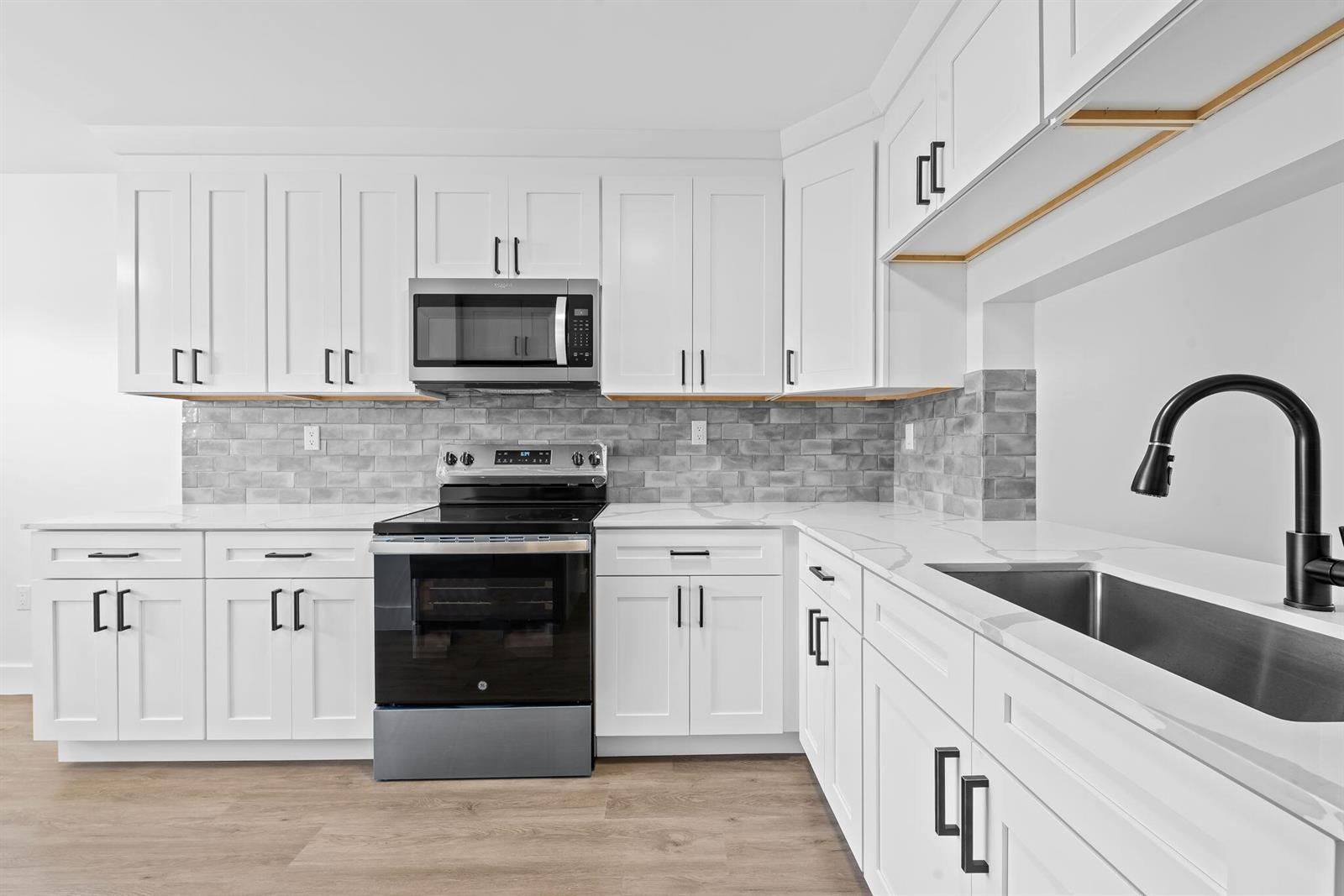 A kitchen features white cabinets, a grey subway tile backsplash, and stainless steel appliances — 4734 E Lucerne Lakes Blvd E # 303, Lake Worth FL 33467, LAKE WORTH, FL