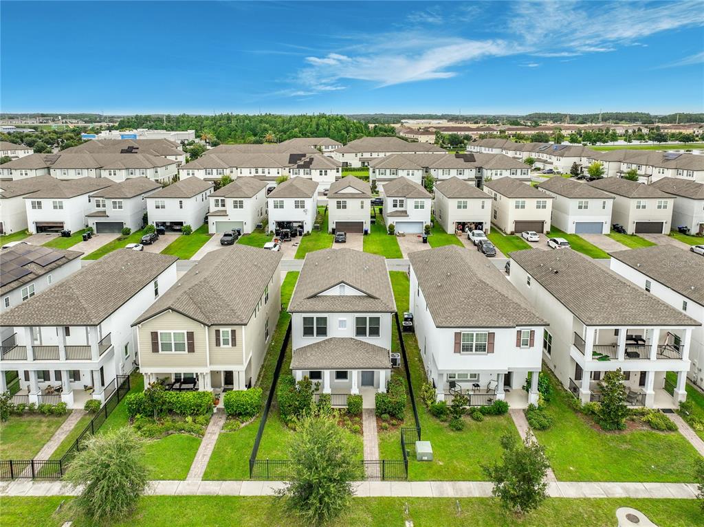 An aerial view shows a row of suburban houses with driveways and small front lawns — 1549 ASTORIA ARBOR LANE, ORLANDO, FL