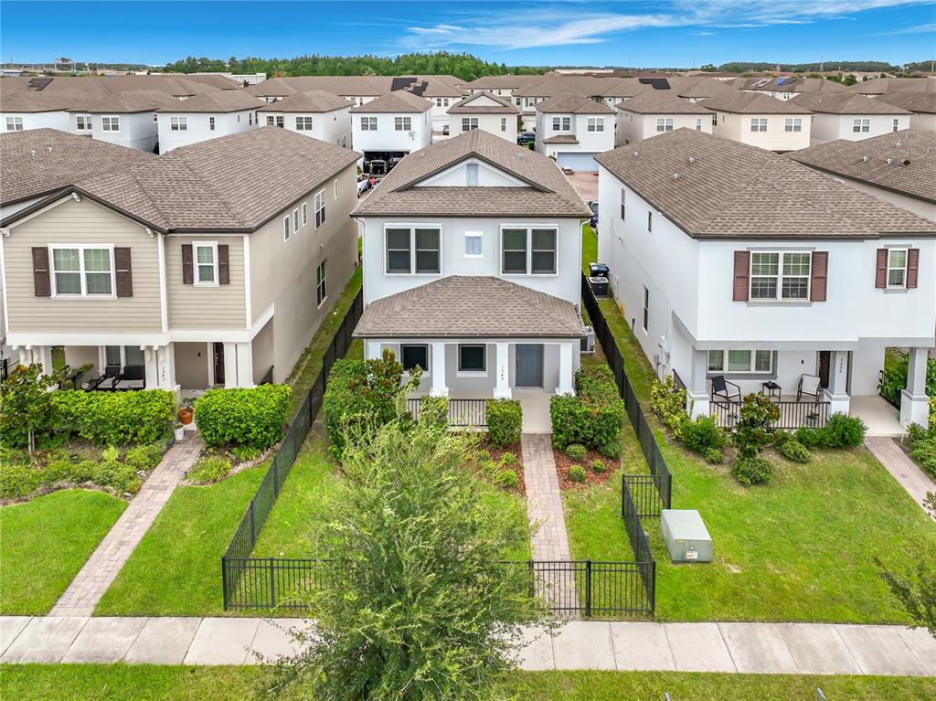 An aerial view shows a two-story house with a fenced front yard and sidewalk — 1549 ASTORIA ARBOR LANE, ORLANDO, FL