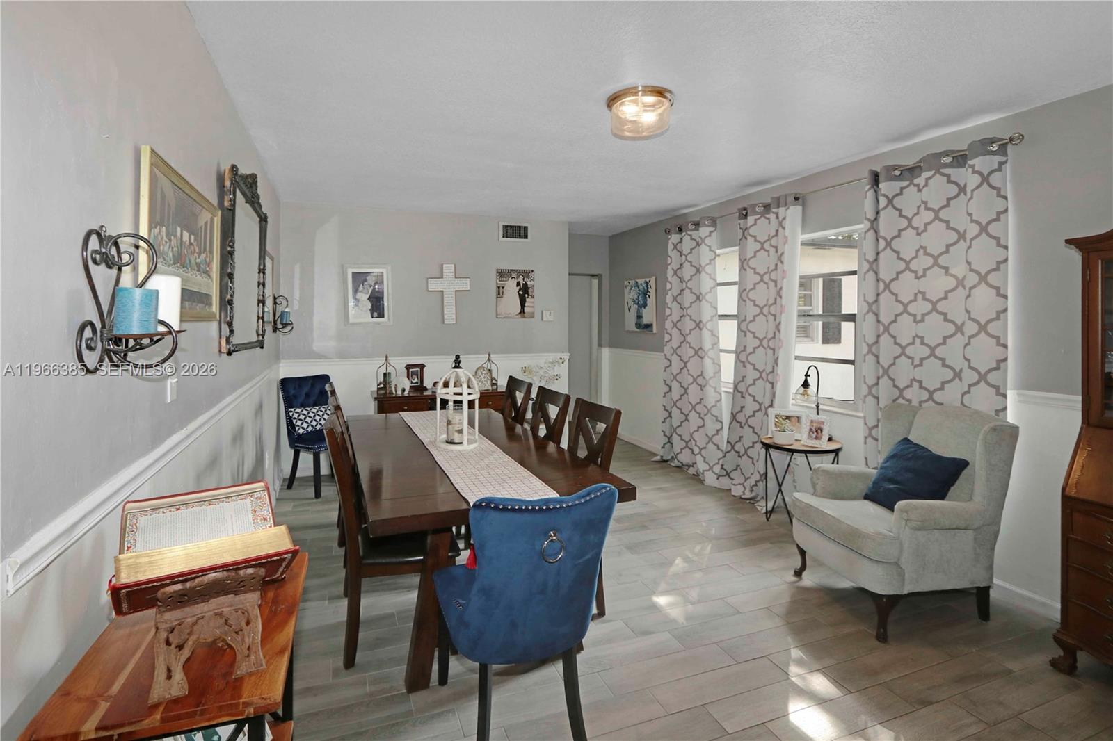 A dining room features a wooden table, blue upholstered chairs, and light gray flooring — 1221 SW 74th Ct, Miami FL 33144, MIAMI, FL