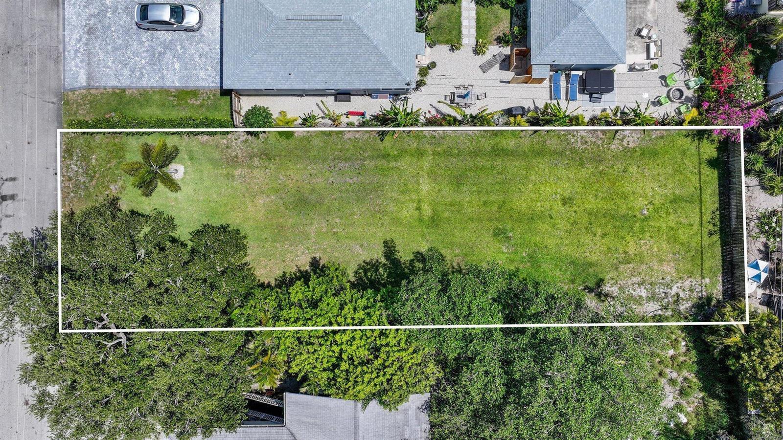 An aerial view shows a rectangular, grassy vacant lot bordered by trees and neighboring houses — 614 N 5th Street, Lantana FL 33462, LANTANA, FL