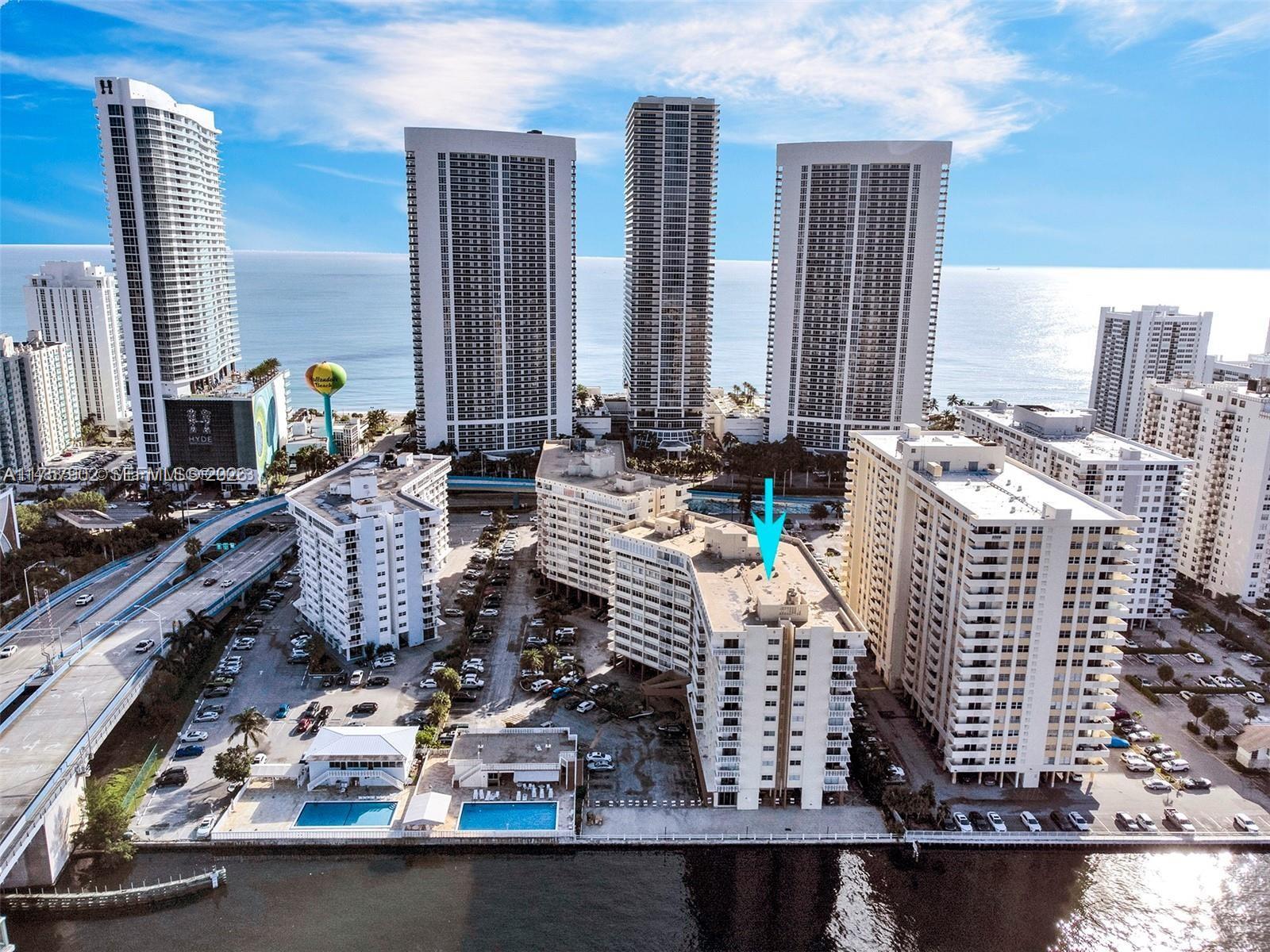 An aerial view shows several high-rise residential buildings near a body of water — 1817 S Ocean Dr # 827, Hallandale Beach FL 33009, HALLANDALE BEACH, FL