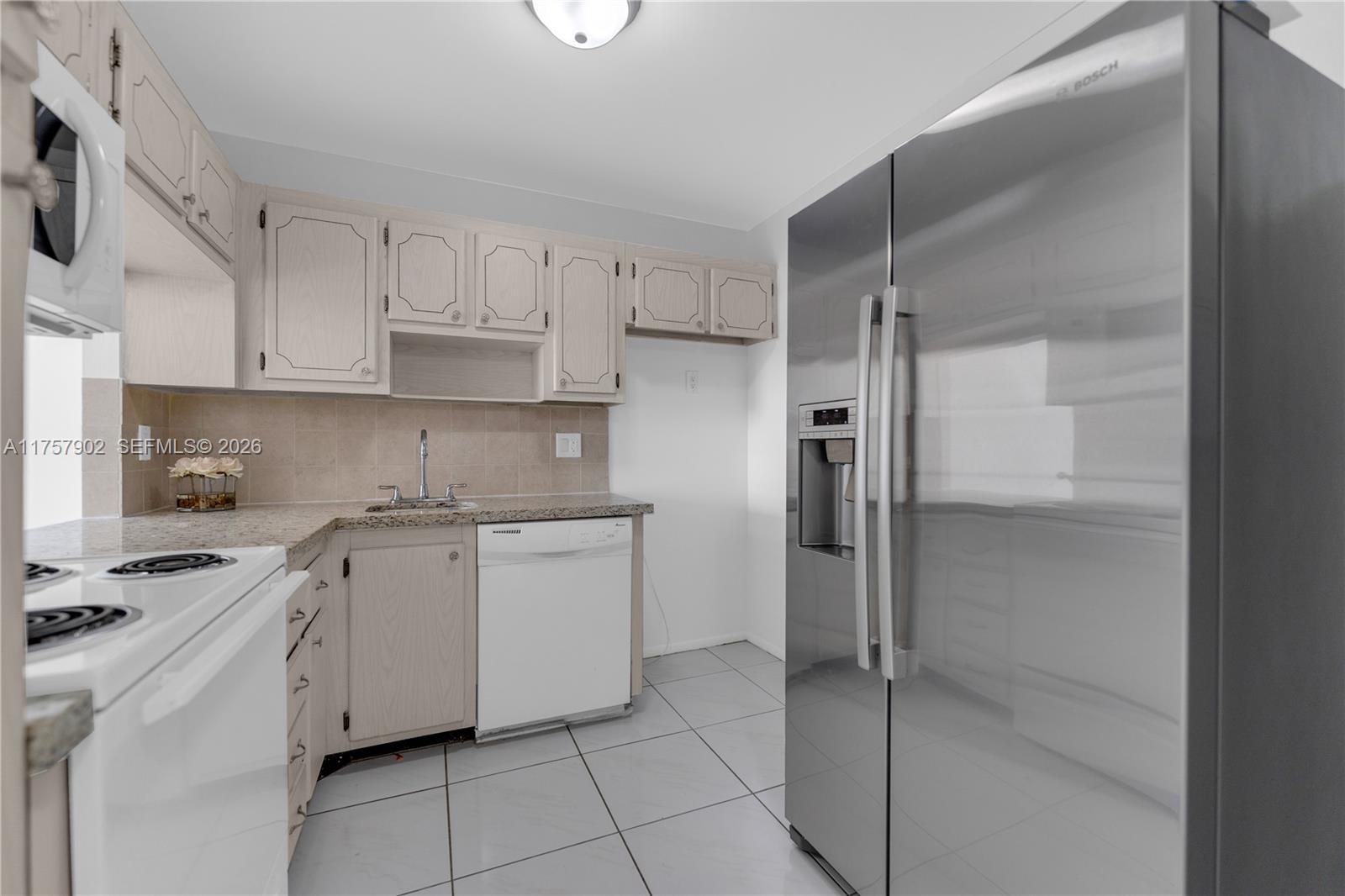 A kitchen features light wood cabinets, a stainless steel refrigerator, and white appliances — 1817 S Ocean Dr # 827, Hallandale Beach FL 33009, HALLANDALE BEACH, FL