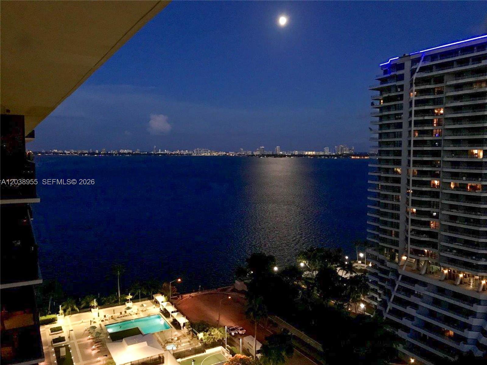 An elevated night view of a bay, a swimming pool, and a high-rise building — 600 NE 36th St # 1017, Miami FL 33137, MIAMI, FL