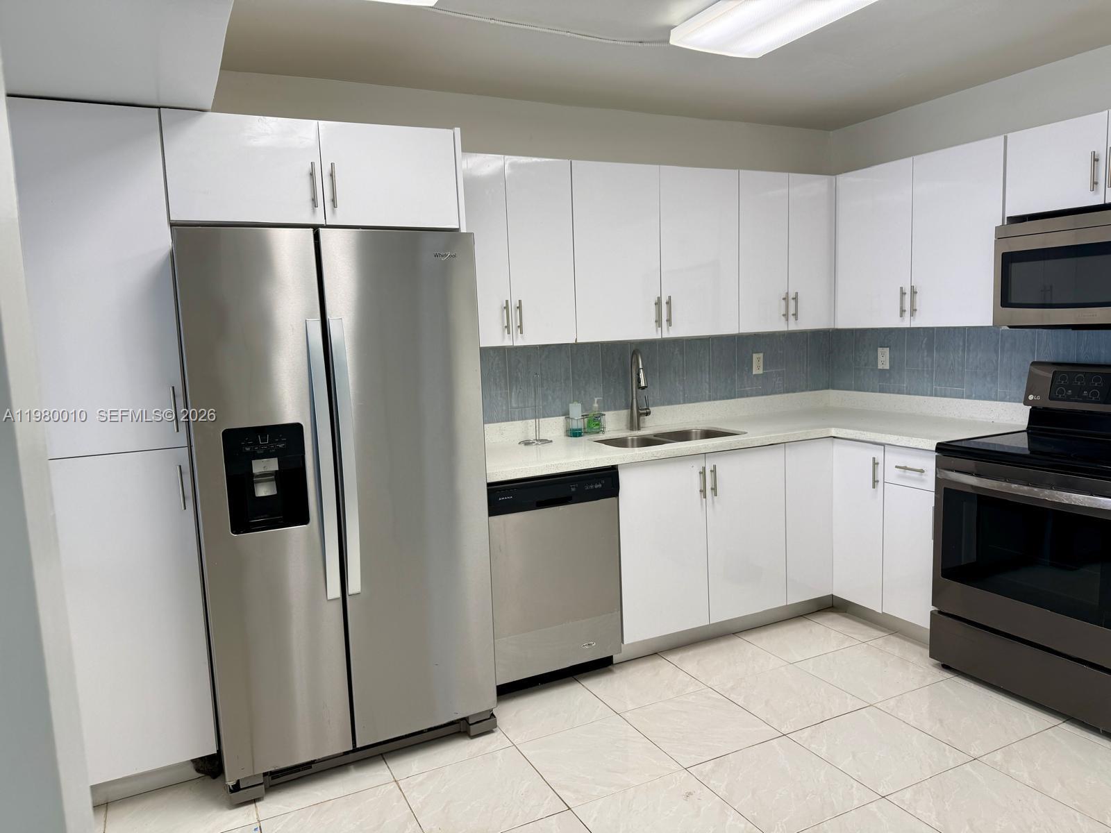 A kitchen featuring white cabinets, stainless steel appliances, a light countertop, and tiled flooring — 20850 San Simeon Way # 5, Miami FL 33179, MIAMI, FL