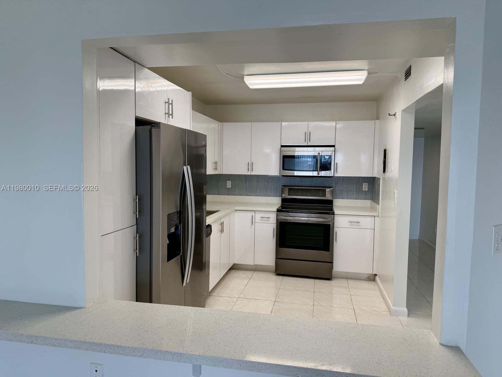 A kitchen features white cabinets, stainless steel appliances, and a light-colored countertop — 20850 San Simeon Way # 5, Miami FL 33179, MIAMI, FL