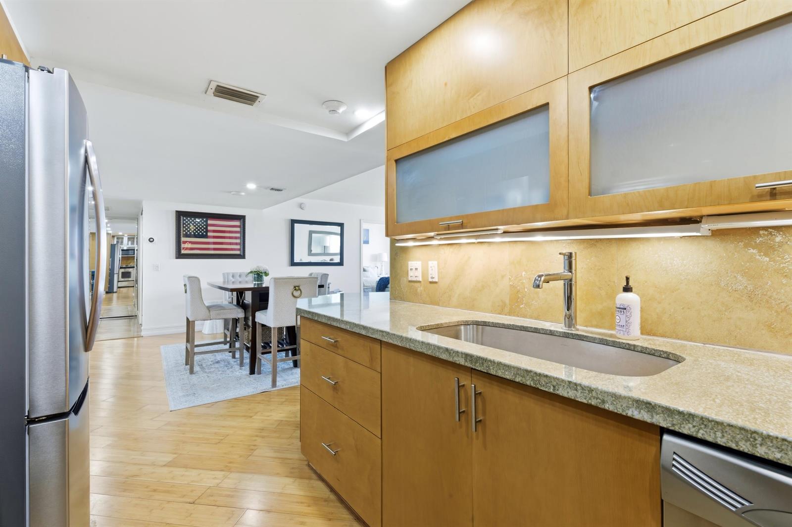 A kitchen with light wood cabinets, granite countertops, and a stainless steel sink — 5600 N Flagler Drive Unit 910, West Palm Beach FL 33407, WEST PALM BEACH, FL