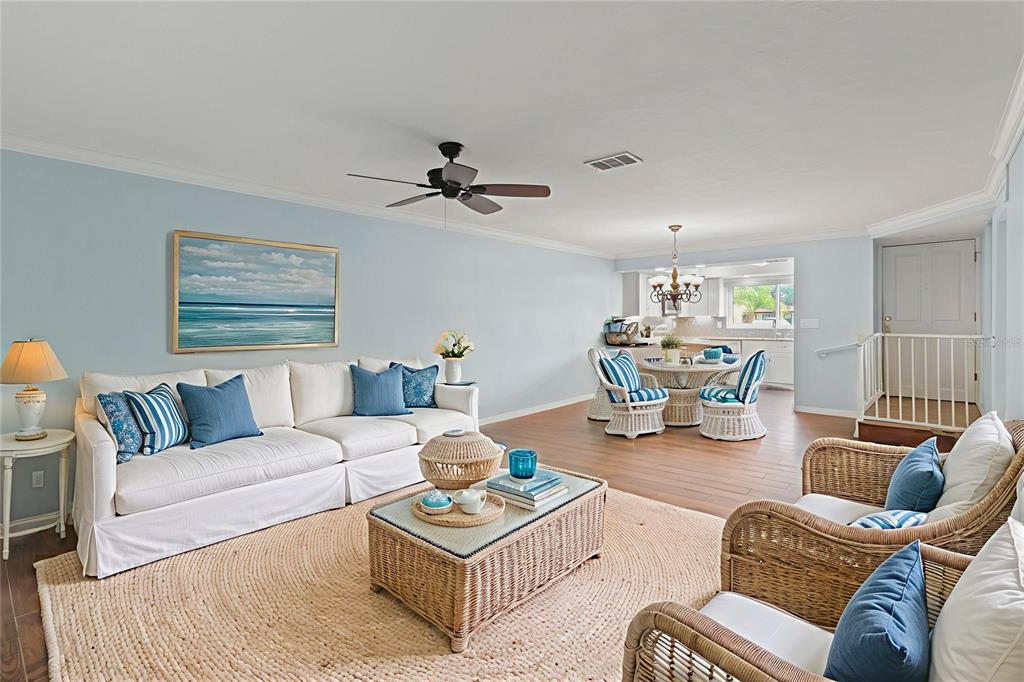 A living room with light blue walls, a white sofa, and wicker furniture — 1446 56TH STREET W UNIT 1446, BRADENTON, FL