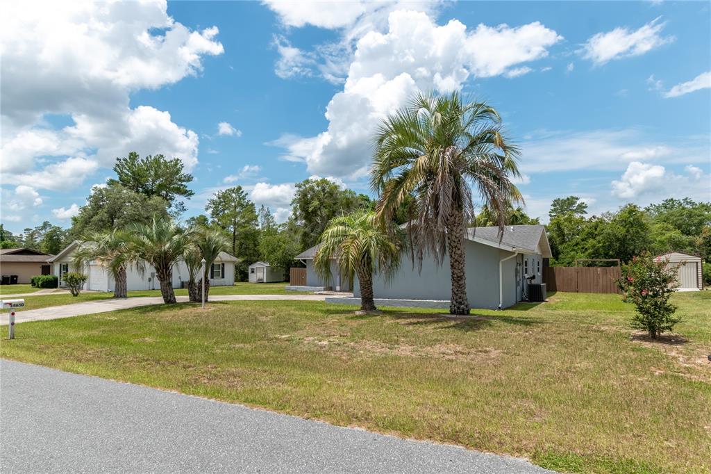 A gray house with palm trees in the front yard under a cloudy blue sky — 14650 SW 29TH AVENUE ROAD, OCALA, FL