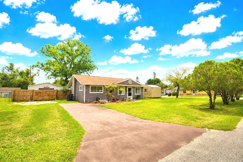 A single-story house with a brown exterior, a driveway, and a large front lawn — 142 MARTHA DRIVE, LAKE WALES, FL