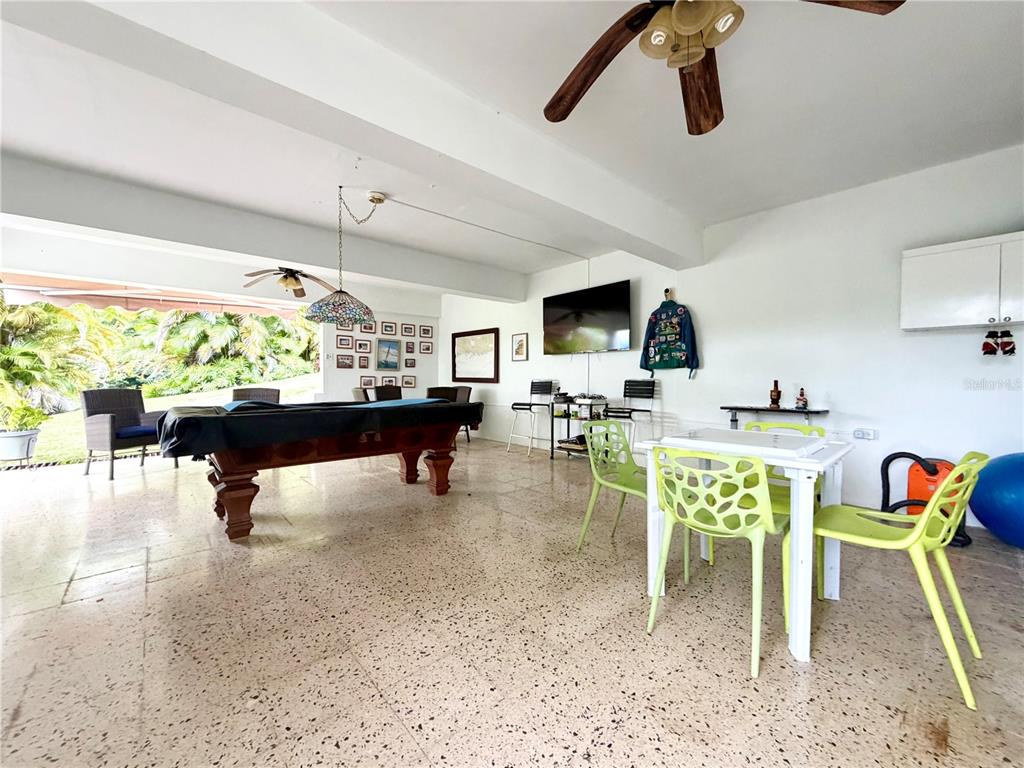 A spacious, tiled game room features a pool table, dining set, and outdoor patio access — 1-E VILLAS DE MONTE VERDE, PONCE, PR