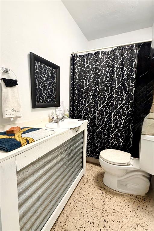 A bathroom features a corrugated metal vanity, a black-framed mirror, and a black patterned shower curtain — 1-E VILLAS DE MONTE VERDE, PONCE, PR