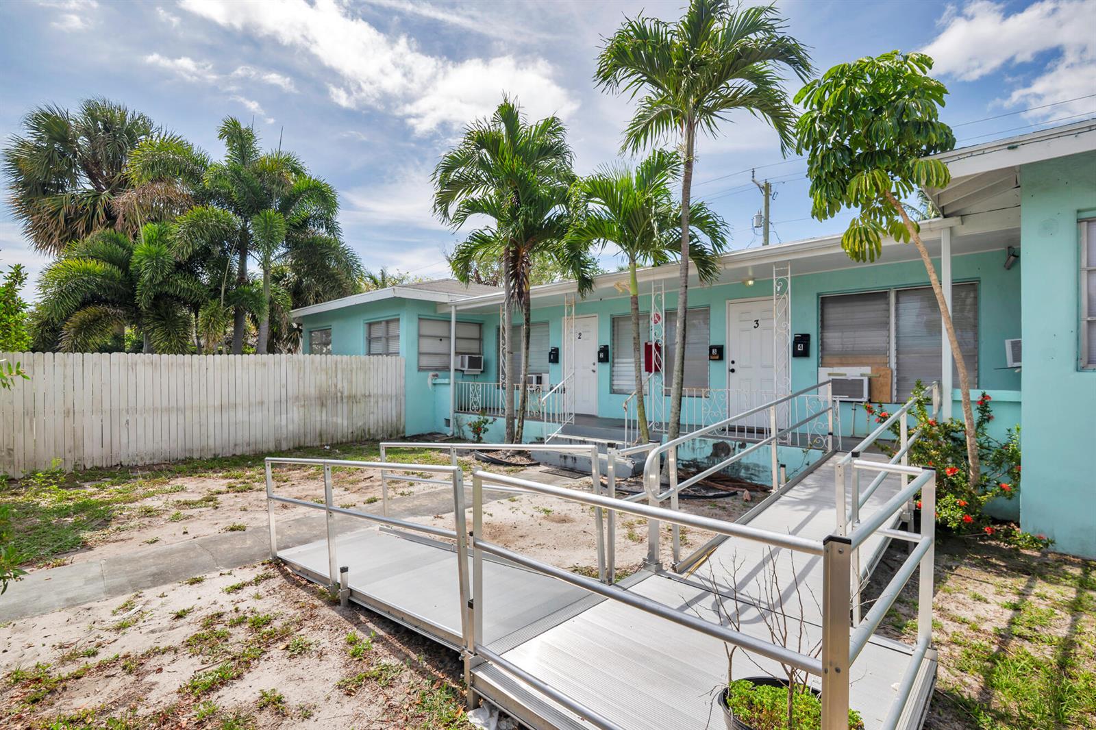 A light blue single-story apartment building with a metal wheelchair ramp in the front yard — 258 Conniston Road, West Palm Beach FL 33405, WEST PALM BEACH, FL