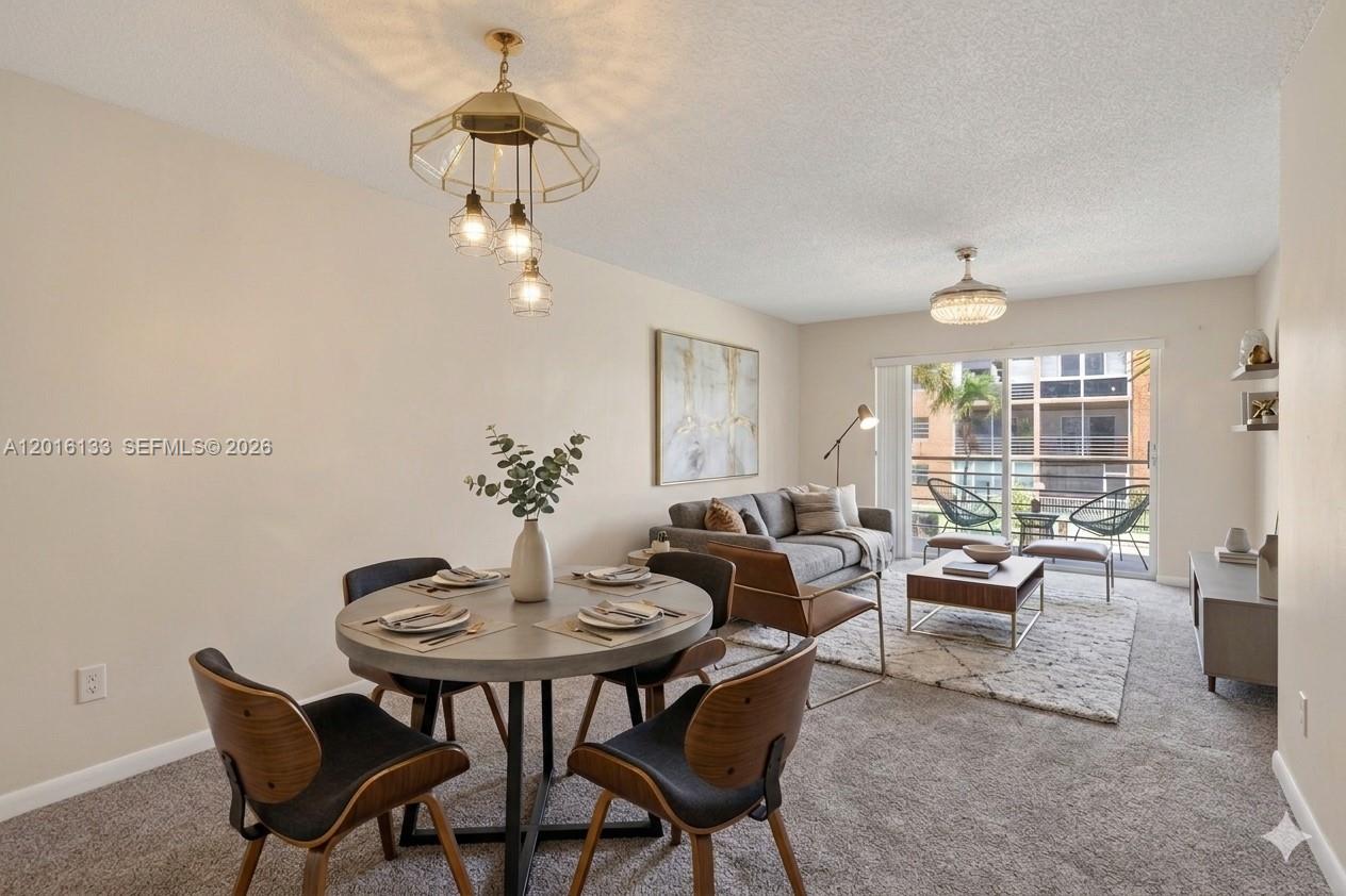 A living and dining room area features a round table, sofa, and sliding glass doors — 3048 E Sunrise Lakes Dr # 220, Sunrise FL 33322, SUNRISE, FL
