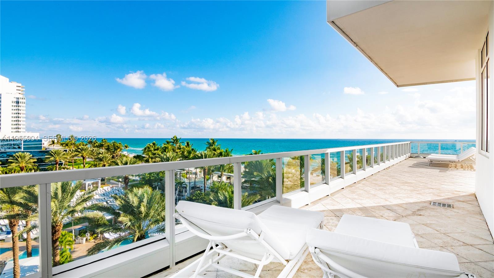 A spacious balcony features white lounge chairs overlooking a tropical beach and the ocean — 4391 Collins Ave, Miami Beach FL 33140, MIAMI BEACH, FL