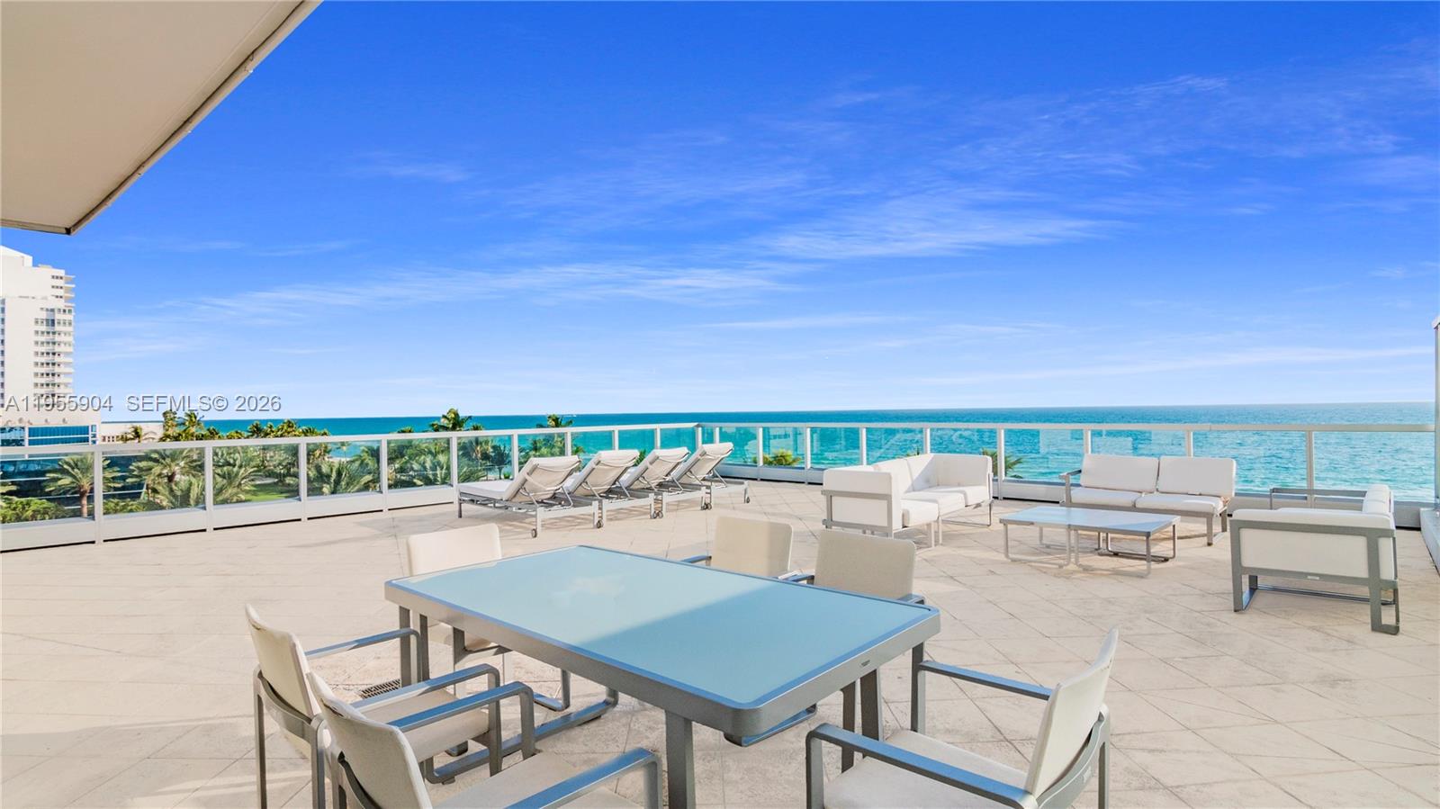 A spacious outdoor terrace features patio furniture, glass railings, and an expansive ocean view — 4391 Collins Ave, Miami Beach FL 33140, MIAMI BEACH, FL