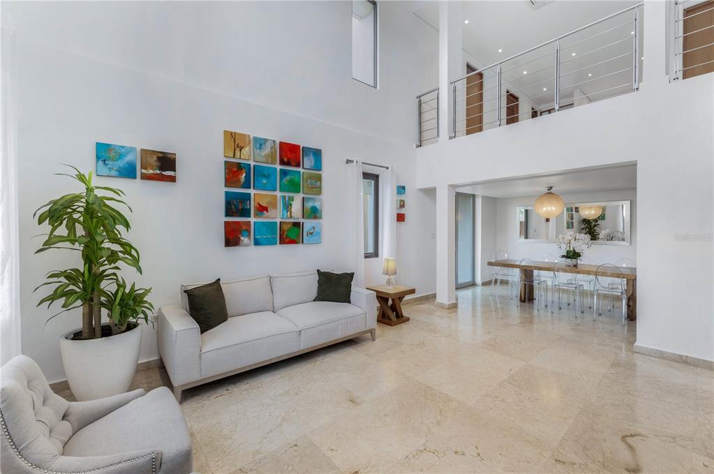 A bright, high-ceilinged living and dining area features white walls, tile floors, and modern decor — 2200 CACIQUE STREET, SAN JUAN, PR