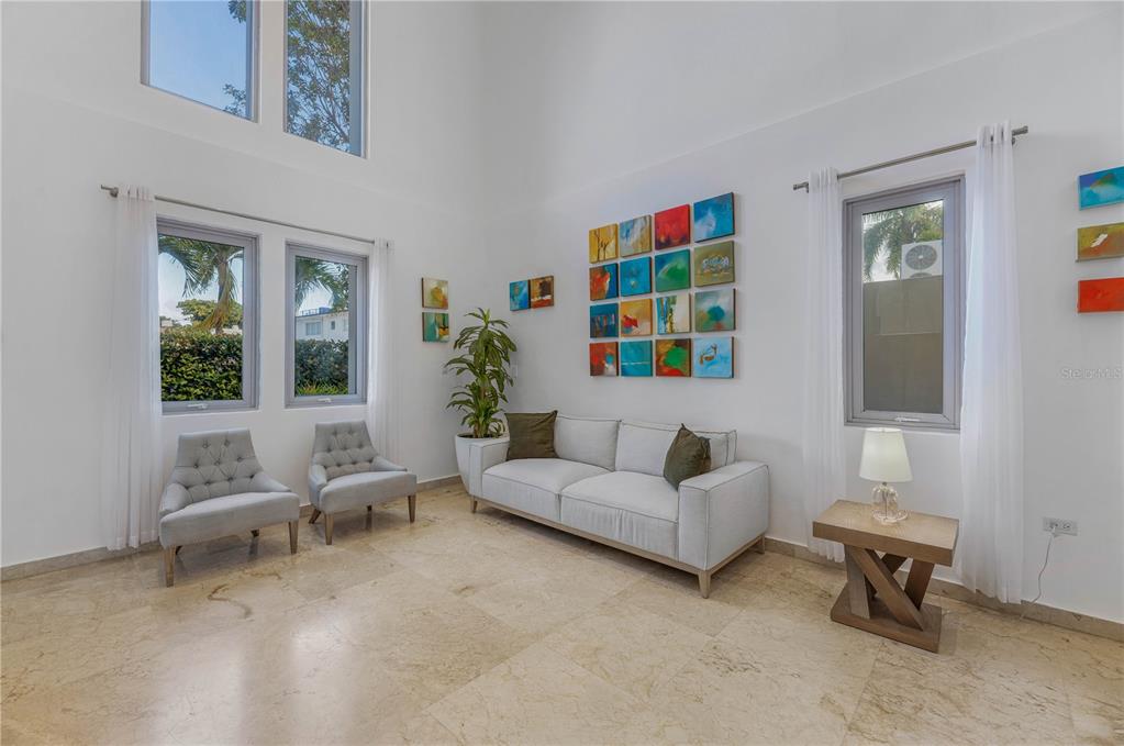 A bright living room features high ceilings, white walls, tile floors, and a modern sofa — 2200 CACIQUE STREET, SAN JUAN, PR