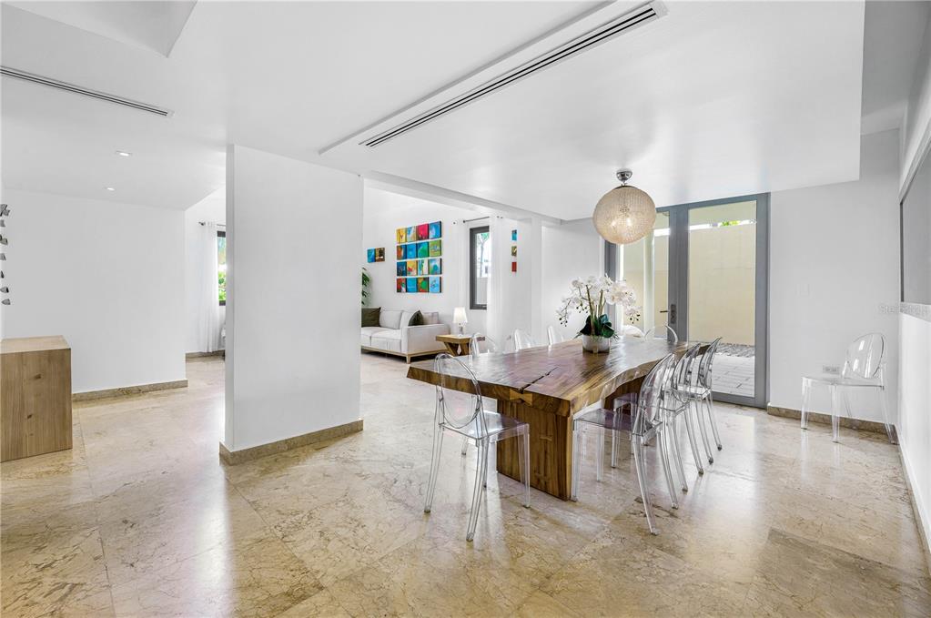 A dining area with a live-edge wood table and clear chairs sits near a living room — 2200 CACIQUE STREET, SAN JUAN, PR