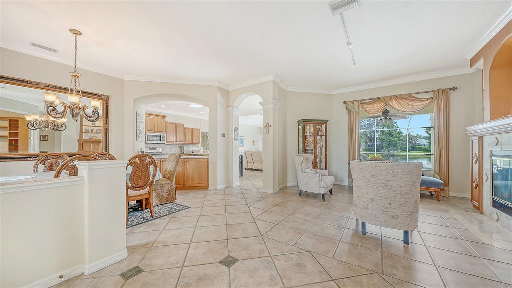 A spacious living and dining area features tile floors, a fireplace, and large window views — 6521 SUNDEW COURT, BRADENTON, FL