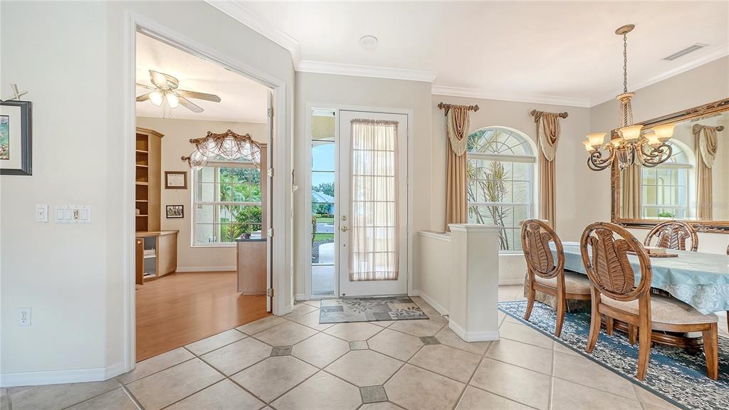 A tiled entryway leads to a dining room with a chandelier and an adjacent office — 6521 SUNDEW COURT, BRADENTON, FL