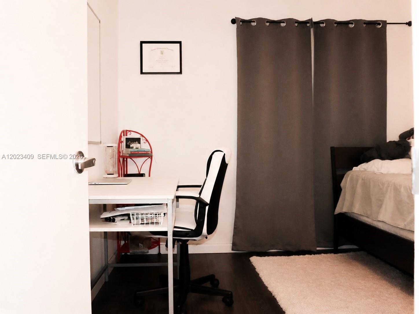 A bedroom features a desk with a chair, a bed, and dark curtains — 500 NE 2nd St # 115, Dania Beach FL 33004, DANIA BEACH, FL