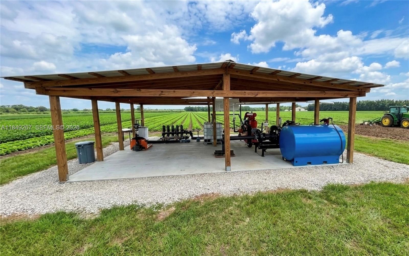 An open-sided wooden structure houses agricultural irrigation equipment and a blue fuel tank — 595 N HEADER CANAL ROAD, Fort Pierce FL 34945, FORT PIERCE, FL