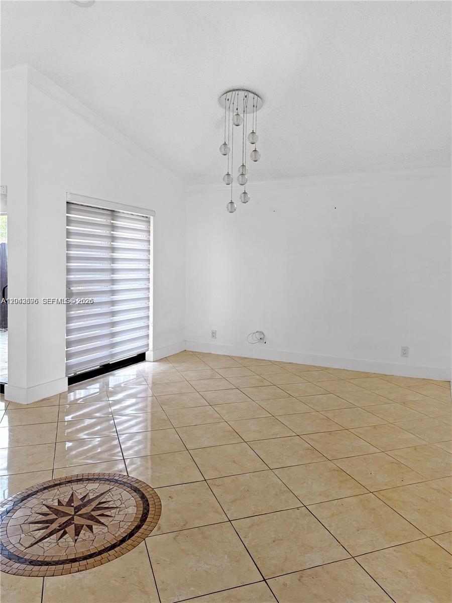 A bright dining area features light-colored tile flooring, a modern pendant light, and sliding doors — 6012 NW 172nd Terr Cir, Hialeah FL 33015, HIALEAH, FL
