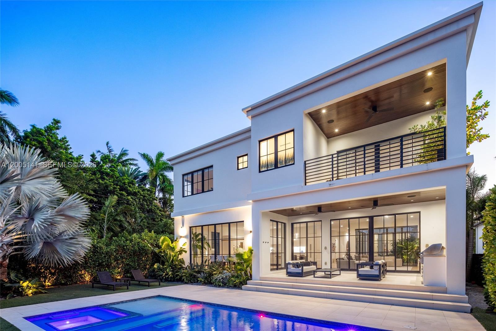 A two-story modern house with a pool, patio, and balcony at dusk — 895 NE 76th St, Miami FL 33138, MIAMI, FL