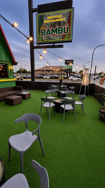 An outdoor patio with artificial turf, dining furniture, and a sign for Bambú Mexican Restaurant — 5731 S. ORANGE BLOSSOM TRAIL, ORLANDO, FL