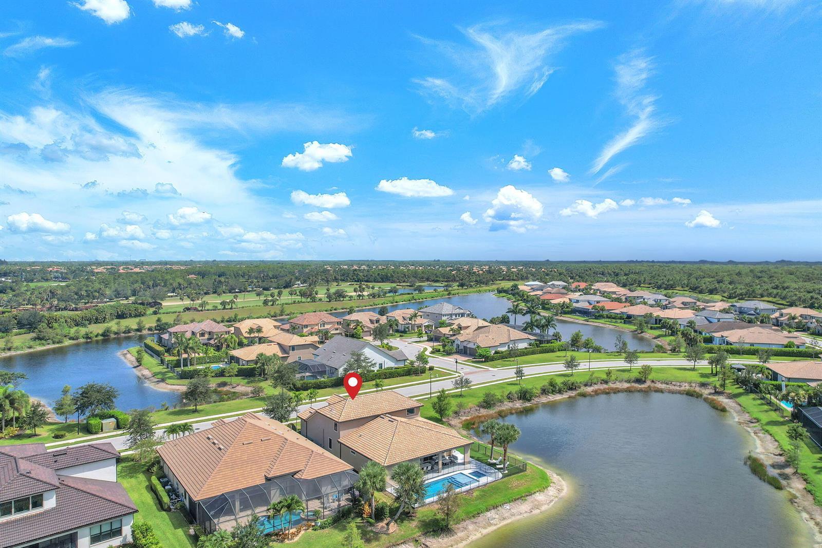 An aerial view shows two houses with pools situated along a lake in a neighborhood — 507 Sonoma Isles Circle, Jupiter FL 33478, JUPITER, FL