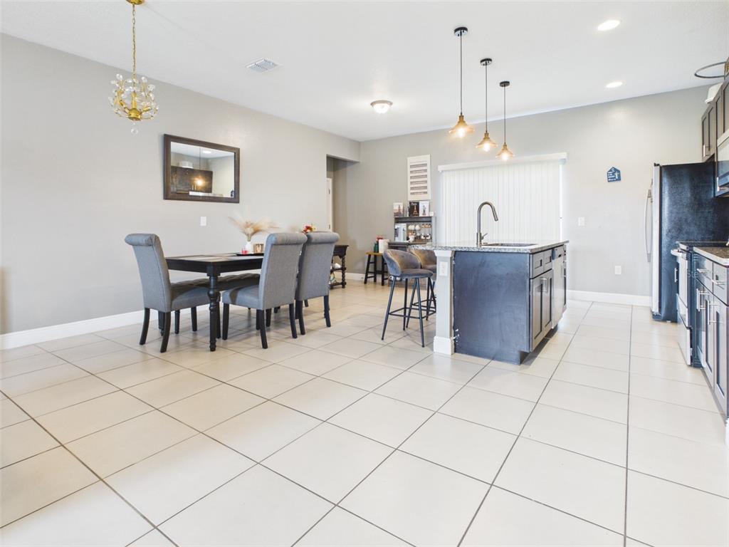 A dining area and kitchen with tile floors, dark cabinetry, and a central island — 14942 SW 24TH CIRCLE, OCALA, FL