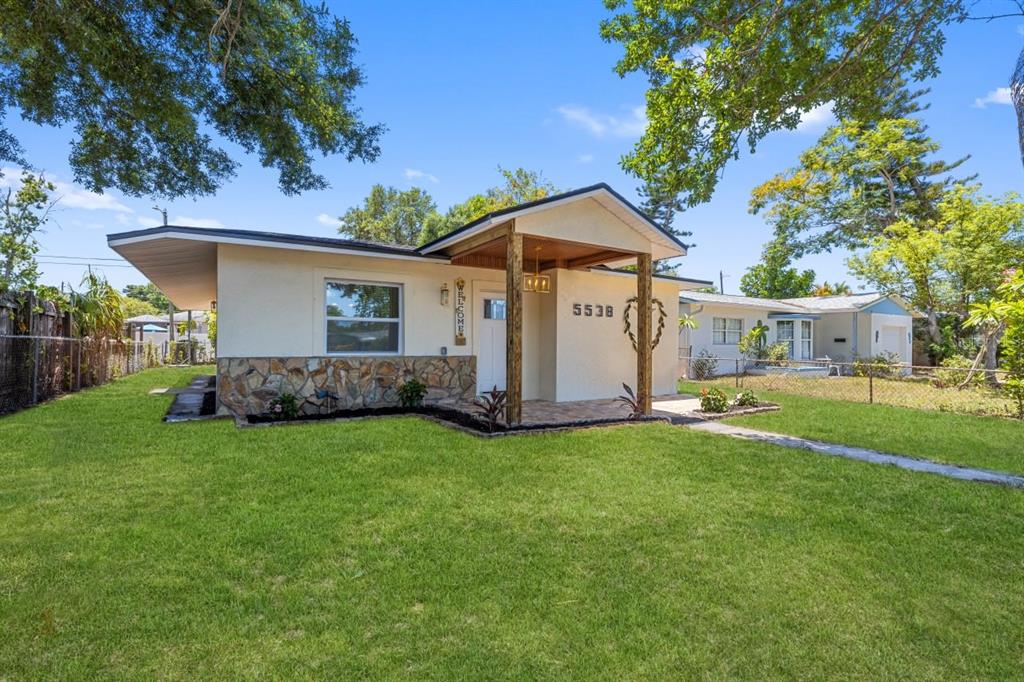 A single-story house with a stone facade, a covered entryway, and a large front lawn — 5538 6TH AVENUE N, ST PETERSBURG, FL