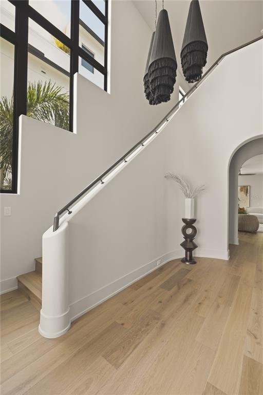 A staircase with a dark metal railing and light wood flooring in a modern entryway — 128 ADRIATIC AVENUE, TAMPA, FL
