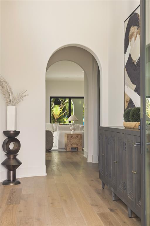 An arched entryway leads into a living room with light wood floors and neutral walls — 128 ADRIATIC AVENUE, TAMPA, FL