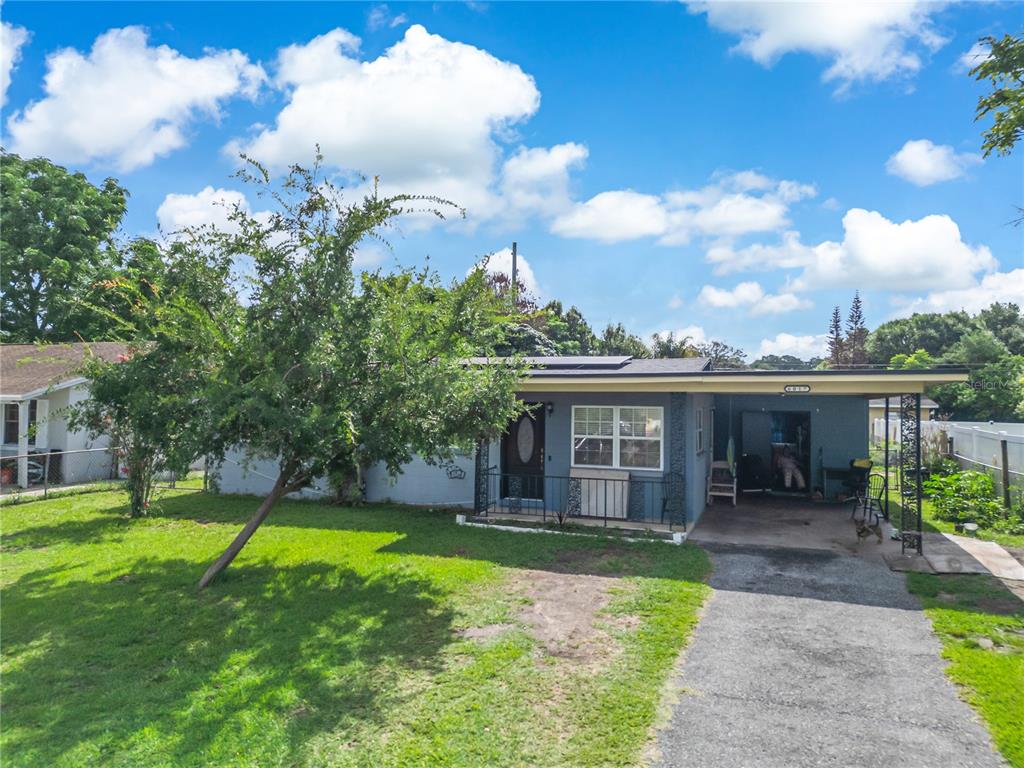 A single-story house with a gray exterior, a front porch, and an attached carport — 6017 CANDLEWOOD LANE, ORLANDO, FL