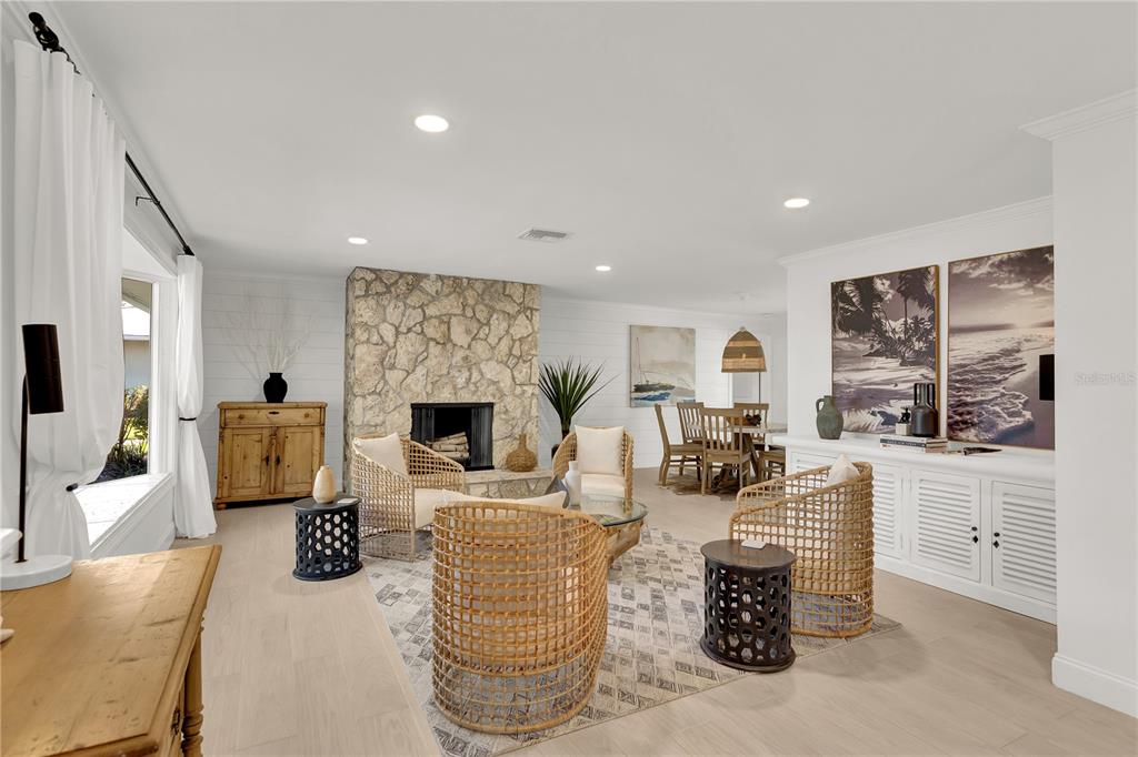 A living room features a stone fireplace, wicker chairs, and a dining area in back — 1945 ANGLERS COVE, VERO BEACH, FL