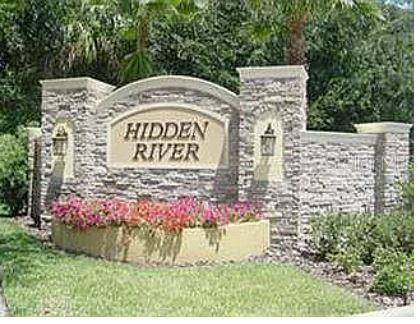 A stone monument sign with the words Hidden River sits in front of lush landscaping — 13805 RIVER FISH COURT, TAMPA, FL