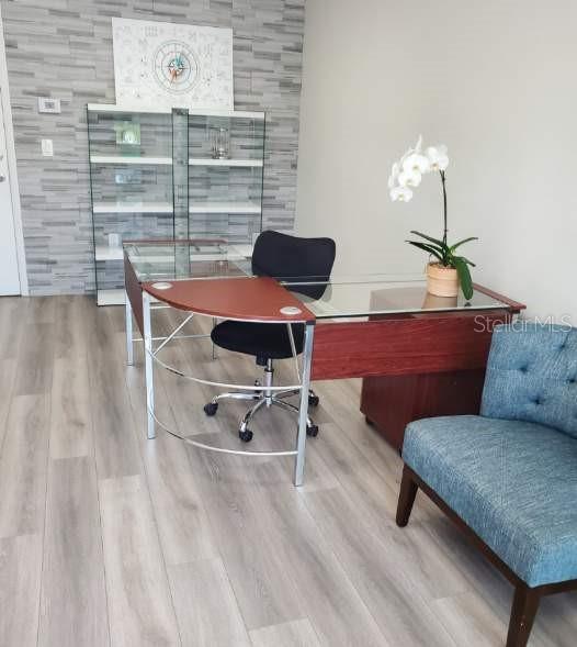 A home office features a glass-topped desk, a black chair, and a blue accent chair — 2730 WORTH AVENUE UNIT 8, ENGLEWOOD, FL